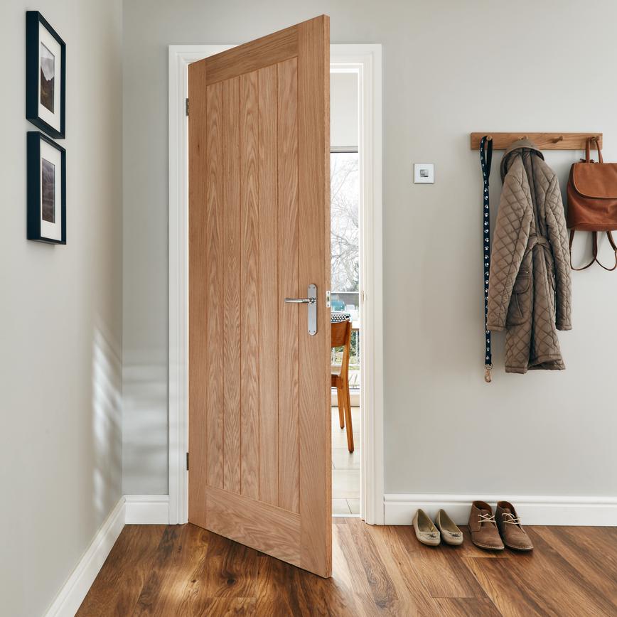 Photograph of a wooden door opening into a dining area